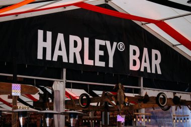 Faaker See, Avusturya - 01 Eylül 2025: Avrupa Bisiklet Haftası 'nda Harley Bar tabelası, festival dekorasyonları ve motosiklet severler için canlı bir atmosfer
