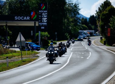 Faaker See, Avusturya - 01 Eylül 2025: Harley-Davidson motosikletli motosikletçiler Avrupa Bisiklet Haftası boyunca yemyeşil bir yeşillik içinde güzel bir yolda seyahat ediyorlar