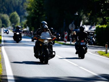 Faaker See, Avusturya - 01 Eylül 2025: Motosikletçiler Avrupa Bisiklet Haftası boyunca Harley-Davidson motosikletleri ve yemyeşil otlakların yer aldığı pitoresk bir yolda gezintiye çıktılar