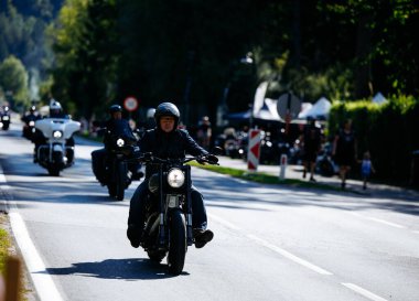 Faaker See, Avusturya - 01 Eylül 2025: Motosikletçiler Avrupa Bisiklet Haftası boyunca Harley-Davidson bisikletleri ve canlı festival atmosferinin yer aldığı manzaralı bir gezinin keyfini çıkarıyorlar