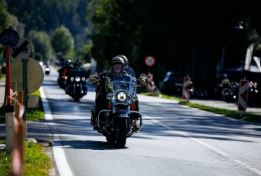 Faaker See, Avusturya - 01 Eylül 2025: Harley-Davidson motosikletçisi Avrupa Bisiklet Haftası boyunca kaskla geziyor, özgürlük ve macera ruhunu yakalıyor