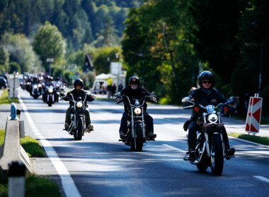 Faaker See, Avusturya - 01 Eylül 2025: Harley-Davidson motosikletli motosikletçiler, ağaçlı güzel bir yol boyunca Avrupa Bisiklet Haftası 'na katıldılar