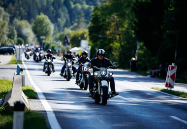 Faaker See, Avusturya - 01 Eylül 2025: Harley-Davidson motosikletli motosikletçiler Avrupa Bisiklet Haftası 'na yeşillikli bir manzara yolu boyunca katılıyor