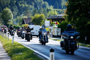 Faaker See, Avusturya - 01 Eylül 2025: Motosikletçiler Avrupa Bisiklet Haftası boyunca Harley-Davidson motosikletleri ve yemyeşil çevresinin yer aldığı manzaranın tadını çıkarıyorlar