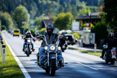 Faaker See, Avusturya - 01 Eylül 2025: Harley sürücüleri, yemyeşil ve açık yollarla çevrili Avrupa Bisiklet Haftası boyunca manzaranın tadını çıkarıyorlar