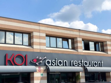 Udine, İtalya - 26 Ağustos 2025: Koi Asya restoranı büyük pencereli ve belirgin bir tabelalı şık bir dış mekâna sahip olup, restoranlar için davetkar bir atmosfer yaratmaktadır.