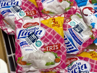Udine, İtalya - 26 Ağustos 2025: Galbani Santa Lucia mozzarella peynir paketleri, taze süt ürünleri ve renkli markaların yer aldığı bir markette düzenlenmiştir.