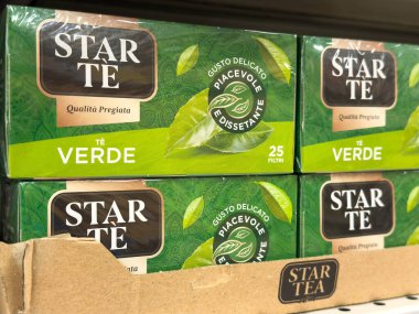 Udine, İtalya - 26 Ağustos 2025: Bir rafta sergilenen yeşil çay kutuları, çay severler için parlak yeşil renkler ve çekici markalar