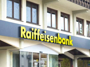 Moosburg, Avusturya - 27 Ağustos 2025: Raiffeisenbank 'ın dışı geniş tabelalı ve birden fazla pencereli modern tasarıma sahiptir.