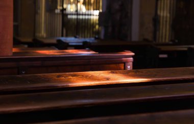 Kilisenin pencerelerinden akan güneş ışığı ahşap bankları aydınlatıyor..