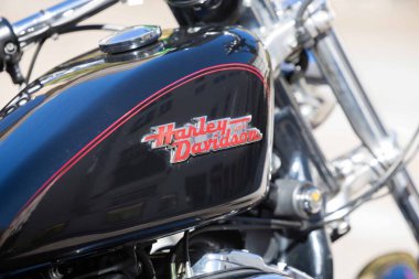 Villach, Avusturya - Eylül 04, 2025: Harley Davidson motorsiklet yakıt tankının yakın görüntüsü logoyu ve krom aksanlı düz siyah yüzeyi vurguluyor