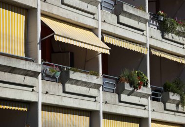 Villach, Avusturya - Eylül 04, 2025: Çizgili tenteler, çiçek açan ve canlı bir şehir atmosferine sahip apartman balkonlarını zenginleştirir