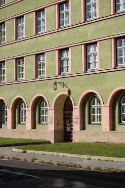 Villach, Avusturya - Eylül 04, 2025: Mimari bina kemerli pencere ve girişi olan yeşil ve pembe renklere sahip, çarpıcı bir görsel etki yaratıyor