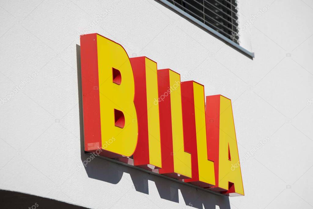 Villach, Austria - September 04, 2025: BILLA sign is clearly visible on a white wall, highlighting the brand's vibrant colors and recognizable logo