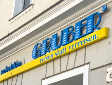 Graz, Avusturya - 06 Eylül 2025: Gruber seyahat acentesinin tabelasında, bir şehir caddesinde belirgin bir şekilde gösterilen parlak mavi ve sarı renkler potansiyel gezginleri cezbediyor