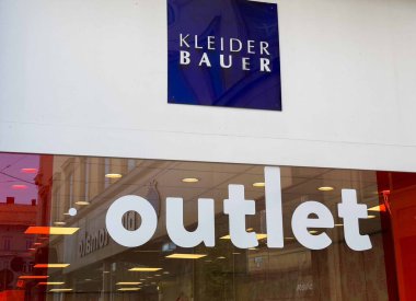 Graz, Avusturya - Eylül 06, 2025: Kleider Bauer mağaza vitrininde parlak bir tabela ile müşterileri canlı bir perakende ortamda moda anlaşmalarını keşfetmeye davet ediyor