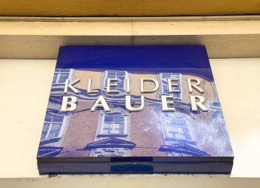Graz, Avusturya - Eylül 06, 2025: Kleider Bauer mağaza tabelası kentsel mimariye karşı hazırlanan parlak mavi bir arka plan içeriyor