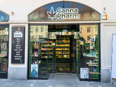 Graz, Avusturya - Eylül 06, 2025: Canna Pharm mağazasında canlı kentsel bir ortamda yağlar ve atıştırmalıklar da dahil olmak üzere çeşitli esrar ürünleri yer alıyor