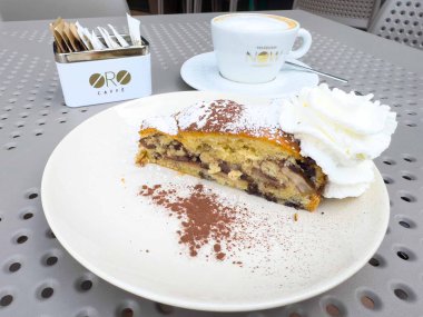 Graz, Avusturya - Eylül 06, 2025: Oro Cafe 'de kremşantili çikolata dilimi tatlı severler için sıcak ve davetkar bir ortam yaratıyor