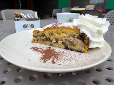 Graz, Avusturya - Eylül 06, 2025: Oro Cafe 'de bir tabakta çırpılmış kremalı çikolata parçacıklı kek harika bir açık hava ortamında tatlıyı davet ediyor