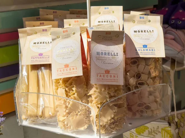 Graz, Avusturya - Eylül 06, 2025: Çeşitli organik makarna tipleri, renkli ambalaj ve sanatsal kalitede Morelli markası vurgulanarak bir pazarda güzelce düzenlenmiştir.