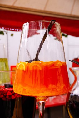 Açık hava etkinliğinde turuncu turuncu renkli, turunçgil ve siyah pipetli canlı bir kokteyl..