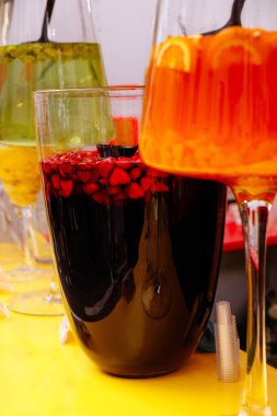 Sarı yüzeydeki cam kaplarda çeşitli meyve içecekleri..