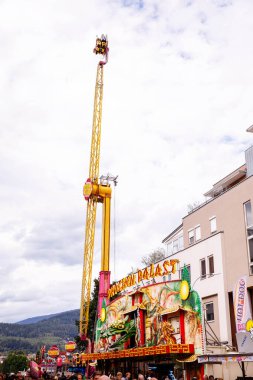 Villach, Avusturya - 30 Temmuz 2025: Heyecanlı kalabalıklarla çevrili Villacher Kirchtag festivalinde eğlenceli bir gezinti, parlak renkler ve şenlikli dekorasyonlar