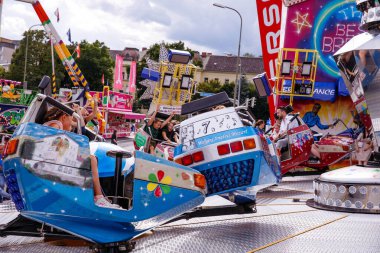 Villach, Avusturya - 30 Temmuz 2025: Villacher Kirchtag Festivali 'nde eğlence gezileri, renkli dekorasyonlar ve şenlikli ortamın keyfini çıkaran neşeli ziyaretçilerle dolu