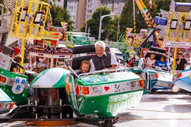 Villach, Avusturya - 30 Temmuz 2025: Büyükbaba ve genç kız Villacher Kirchtag festivalinde eğleniyorlar.