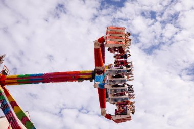 Villach, Avusturya - 30 Temmuz 2025: Villacher Kirchtag Festivali 'nde heyecan verici bir eğlence gezisi, renkli bir gökyüzü arkaplanına karşı heyecan verici biniciler sergileniyor