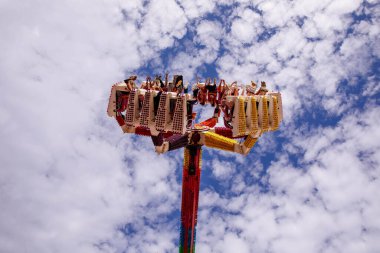 Villach, Avusturya - 30 Temmuz 2025: Villacher Kirchtag Festivali 'nde heyecan verici bir eğlence gezisi, neşeli binicilerin pofuduk bulutlar ve parlak renklere karşı durduğu