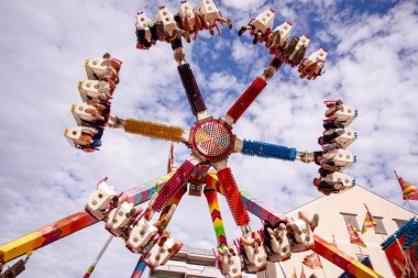 Villach, Avusturya - 30 Temmuz 2025: Villacher Kirchtag Festivali 'nde eğlenceli bir gezinti, yukarıda dönen heyecanlı binicilerin yer aldığı, canlı bir atmosfer yaratan
