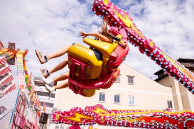 Villach, Avusturya - 30 Temmuz 2025: Heyecanlı sürücüler, Villacher Kirchtag festivalinde renkli dekorasyonlar ve şenlikli atmosferle çevrili heyecanlı bir gezinti yaşadılar