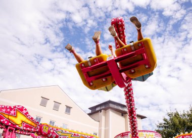 Villach, Avusturya - 30 Temmuz 2025: Villacher Kirchtag Festivali 'nde heyecan verici bir eğlence gezisi, havada bacakları ve renkli panayır atmosferi olan sürücüler