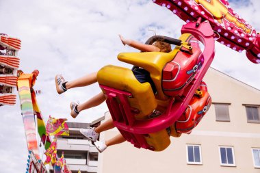 Villach, Avusturya - 30 Temmuz 2025: Çocuklar Villacher Kirchtag festivalinde renkli dekorasyonlar ve neşeli ambiyanslarla çevrili heyecan verici bir yolculuk yaşıyor