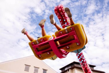 Villach, Avusturya - 30 Temmuz 2025: Villacher Kirchtag festivalinde renkli koltuklar ve parlak gökyüzüne doğru süzülen neşeli sürücüler