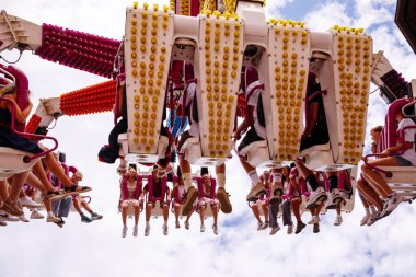 Villach, Avusturya - 30 Temmuz 2025: Villacher Kirchtag Festivali 'nde heyecanlı bir eğlence gezisi, baş aşağı binicilerin canlı renkleri ve canlı bir atmosferi var
