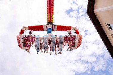 Villach, Avusturya - 30 Temmuz 2025: Villacher Kirchtag festivalinde parlak mavi gökyüzüne karşı yükselen neşeli sürücüler