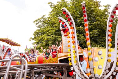 Villach, Avusturya - 30 Temmuz 2025: Villacher Kirchtag festivalinde renkli dekorasyonlar ve hareketli ambiyansla çevrili neşeli sürücüler