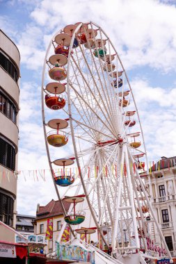 Villach, Avusturya - 30 Temmuz 2025 Villacher Kirchtag festivalinde canlı bir dönme dolap, renkli gondollar ve şenlikli bayraklarla süslenmiş, canlı bir sahne yaratıyor.