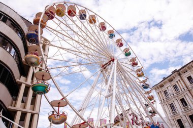 Avusturya 'nın Villach kenti - 30 Temmuz 2025: Vibrant dönme dolap Avusturya' daki Villacher Kirchtag festivalinde renkli gondollar ve fotokopi alanı ile çarpıcı bir gökyüzü arkaplanı