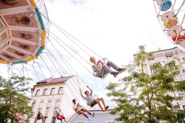 Villach, Avusturya - 30 Temmuz 2025: Çocuklar Villacher Kirchtag festivalinde renkli dekorasyonlar ve canlı ambiyansla eğleniyorlar