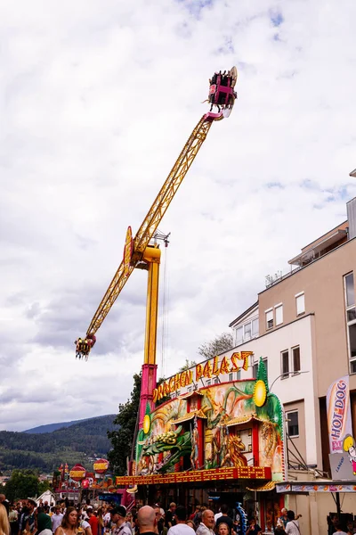 Villach, Avusturya - 30 Temmuz 2025: Villacher Kirchtag Festivali 'nde eğlenceli bir gezinti, renkli dekorasyonlar ve canlı bir ortam ile neşeli kalabalıkların üzerinde yükseliyor