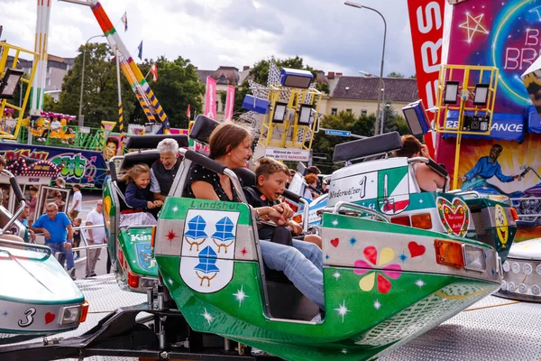 Villach, Avusturya - 30 Temmuz 2025: Çocuklar Villacher Kirchtag festivalinde eğleniyorlar, arka planda hareketli bir eğlence ve kalabalık var