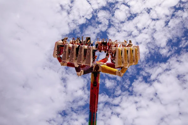 Villach, Avusturya - 30 Temmuz 2025: Villacher Kirchtag Festivali 'nde heyecan verici bir eğlence gezisi, neşeli binicilerin pofuduk bulutlar ve parlak renklere karşı durduğu