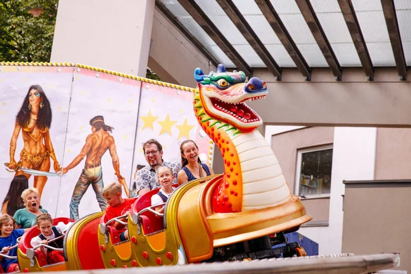 Villach, Avusturya - 30 Temmuz 2025: Villacher Kirchtag festivalinde ejderha temalı yolculuk, neşeli çocuklar ve yetişkinlerin etkinliğin eğlenceli atmosferini deneyimlemesi
