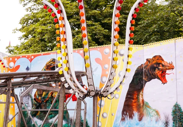 Villach, Avusturya - 30 Temmuz 2025: Eğlence gezisi, Villacher Kirchtag festivalinde neşeli bir sahne yaratan parlak ışıklar ve dinozor duvar resmi içeriyor