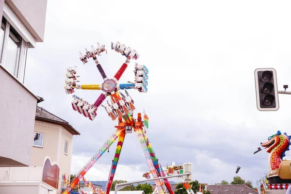 Villach, Avusturya - 30 Temmuz 2025: Villacher Kirchtag festivalinde neşeli dekorasyonlar ve neşeli atmosferle çevrili renkli dönme dolap