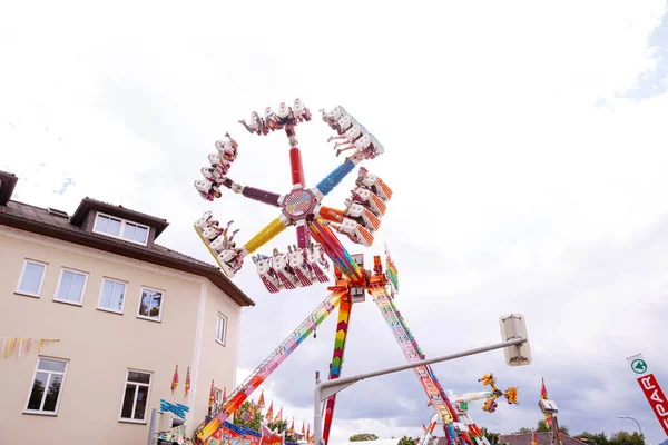 Villach, Avusturya - 30 Temmuz 2025: Vibrant dönme dolap Villacher Kirchtag festivalinde renkli dekorasyonlar ve yakınlardaki binalar canlı bir sahne yaratıyor